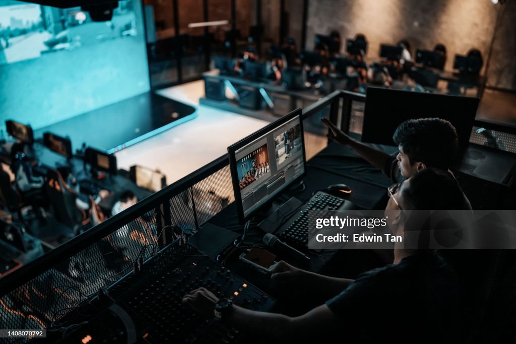 Asiatische Sport-Event-Crew, die hinter den Kulissen mit Bedienfeld an Bühnenbeleuchtung, Soundsystem und Lichteffekt arbeitet