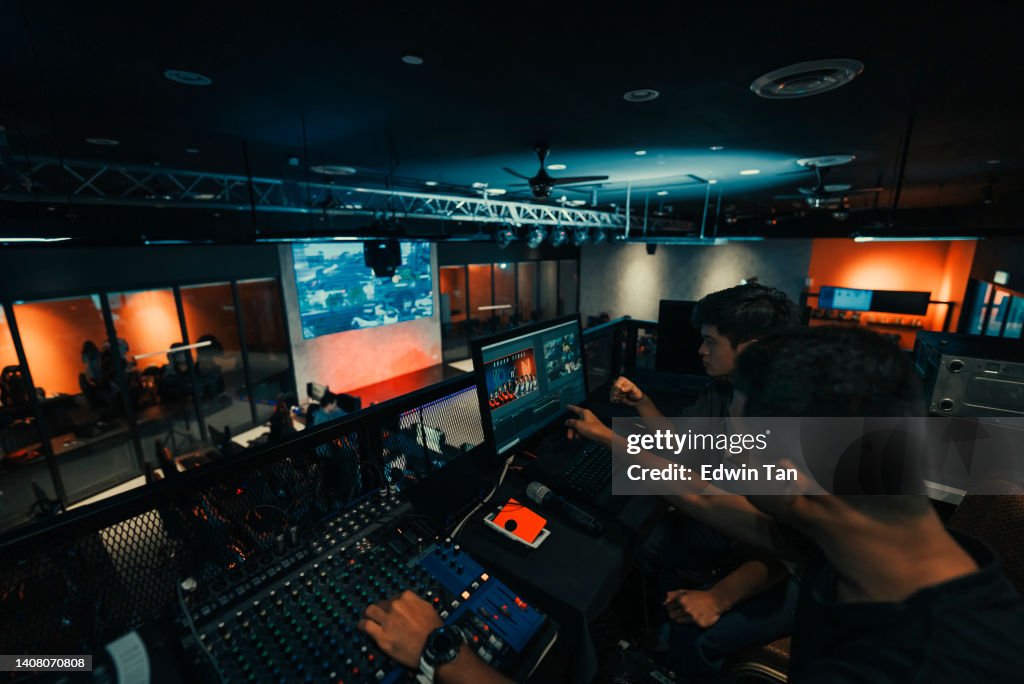 Asian sports event crew working at backstage with control panel on stage lighting , sound system and lighting effect
