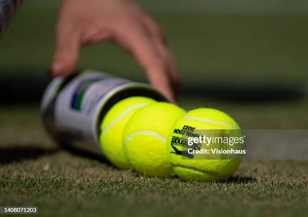 Centre Court ball boy opens a can of new balls on day fourteen of The Championships Wimbledon 2022 at All England Lawn Tennis and Croquet Club on...