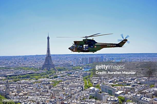 French army Puma helicopter flies over the Eiffel Tower during a French army aerial rehearsal parade before Bastille Day on July 11, 2022 in Paris,...