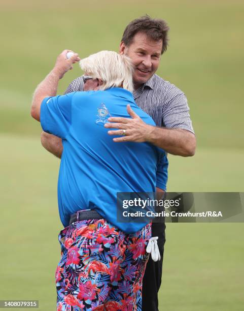 John Daly of the United States and Sir Nick Faldo of England embrace during the Celebration of Champions prior to The 150th Open at St Andrews Old...