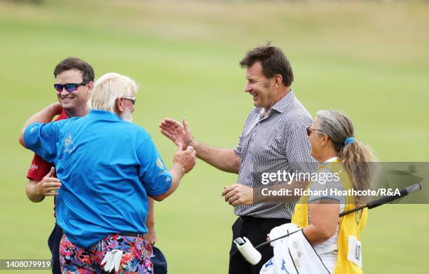 Zach Johnson of the United States, John Daly of the United States, Sir Nick Faldo of England and Fanny Sunesson embrace on the 18th hole during the...