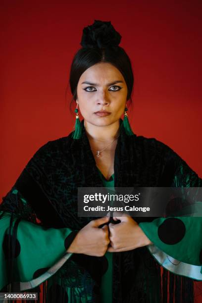 portrait of a woman, flamenco dancer, dressed in flamenco costume “traje de flamenca or vestido de gitana”. a red wall in the background. flamenco, dance, gypsies, tradition, popular, concept. - vestido rosa stock pictures, royalty-free photos & images