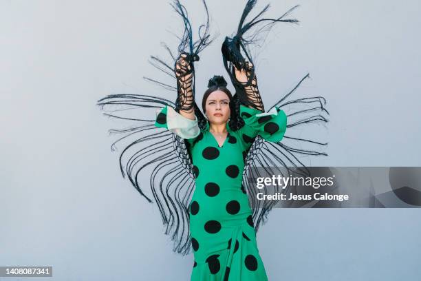 woman, flamenco dancer, dancing in the street, dressed in flamenco costume “traje de flamenca or vestido de gitana”. flamenco, dance, gypsies, tradition, popular, spain, concept. - vestido rosa stock pictures, royalty-free photos & images