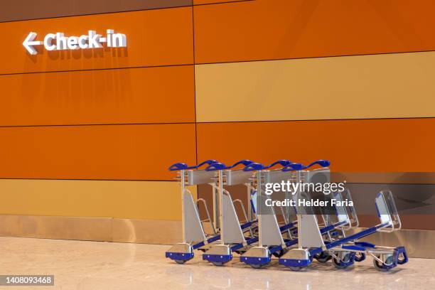 airport entrance with signage indicating the check-in area / next to luggage carts - cartgate out stock pictures, royalty-free photos & images