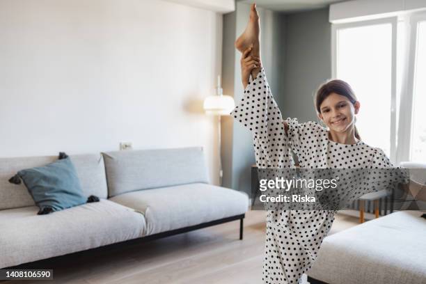 teenage girl practicing ballet at home - leg stretch girl stock pictures, royalty-free photos & images