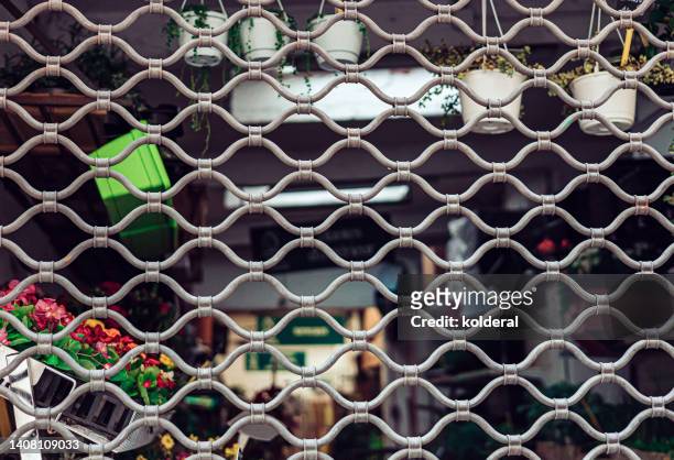 closeup of security grilles rolling door of the florist store - metal grate fotografías e imágenes de stock