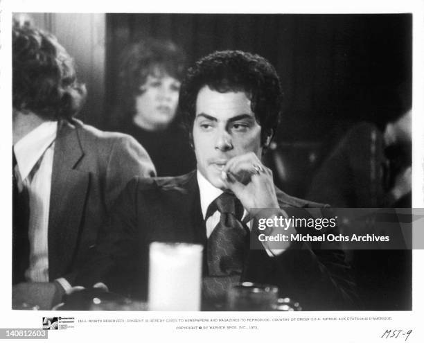 Richard Romanus sitting at a table smoking a cigarette in a scene from the film 'Mean Street', 1973.