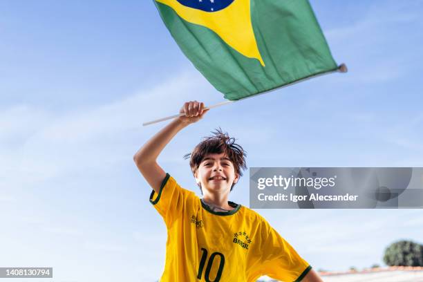brazil fan boy running with flag - a brazil supporter stockfoto's en -beelden