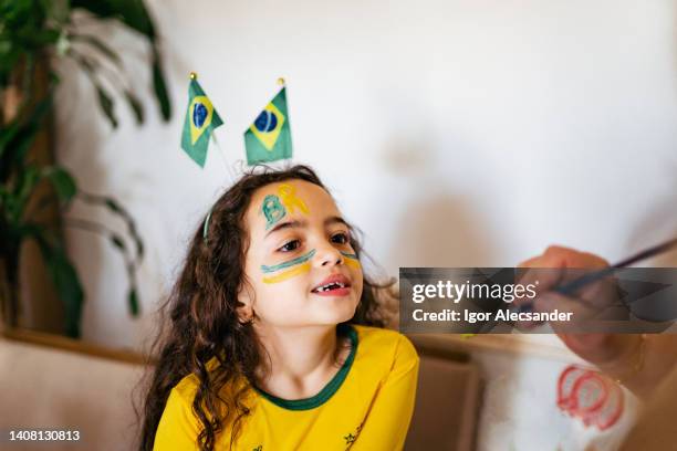 brazilian girl painting her face - brazil girls supporters stock pictures, royalty-free photos & images