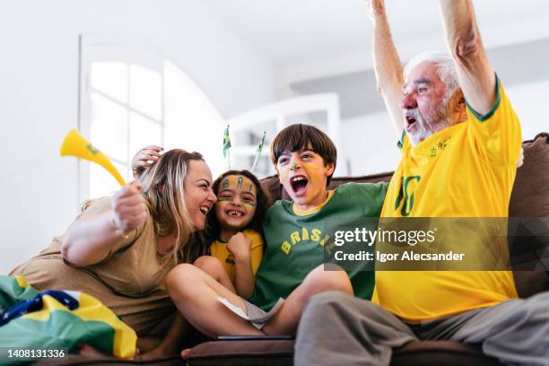 family at home celebrating a brazil goal - world cup brazil stock pictures, royalty-free photos & images