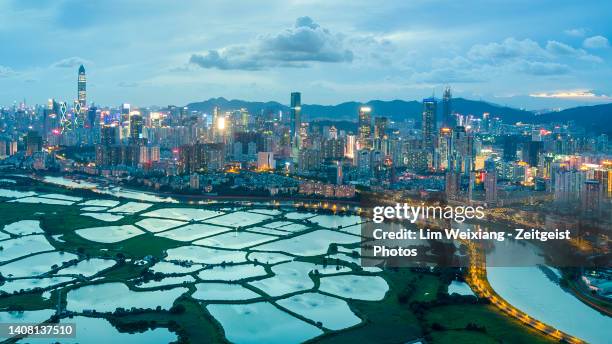 dusk aerial shot of fish farms next to a metropolis - shenzhen stock pictures, royalty-free photos & images