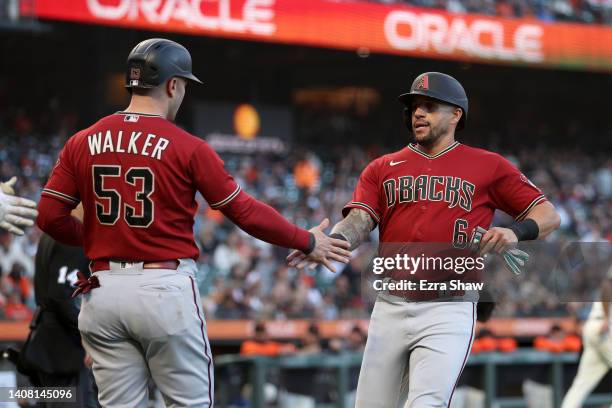 Christian Walker congratulates David Peralta of the Arizona Diamondbacks after they both scored in the third inning against the San Francisco Giants...