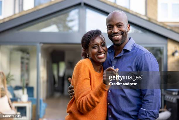 happy black couple holding the keys of their new house - home ownership keys stock pictures, royalty-free photos & images