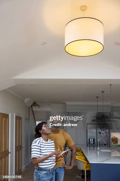 paar, das die lichter in seinem haus mit einem automatisierten system steuert - dimmer stock-fotos und bilder