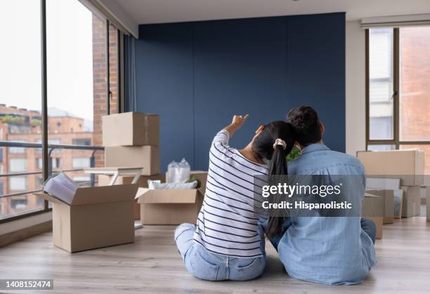 couple moving house and thinking about how to decorate a wall - tenant imagens e fotografias de stock