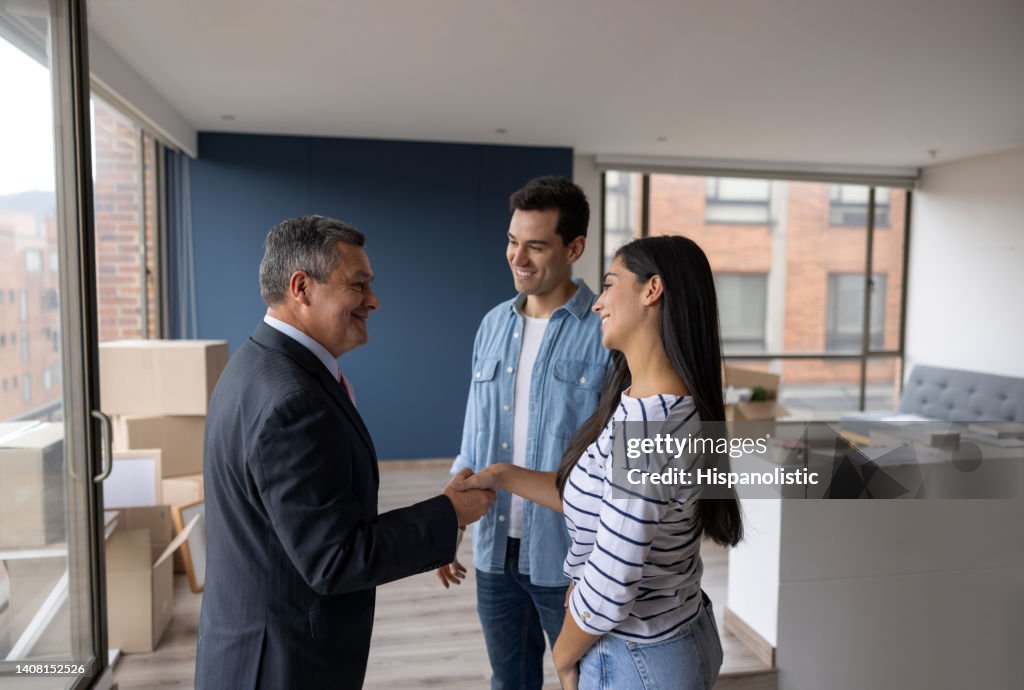 Real Estate Agent selling an apartment to a couple and closing the deal with a handshake