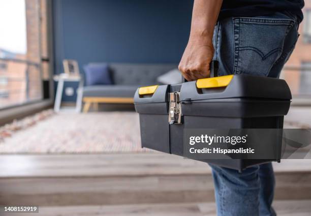 gros plan sur un électricien portant une boîte à outils tout en travaillant dans une maison - boîte à outils photos et images de collection