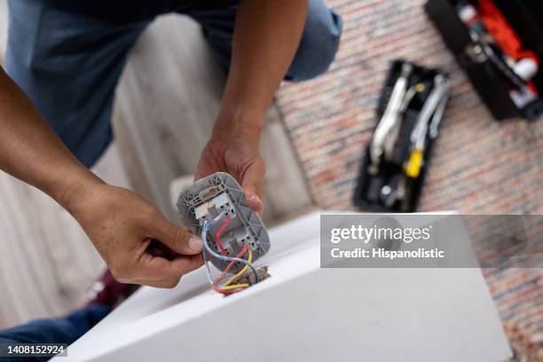 close-up on a repairman fixing an electrical outlet - tegen de stroom in stockfoto's en -beelden