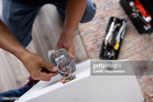 close-up on a repairman fixing an electrical outlet - elétrico imagens e fotografias de stock