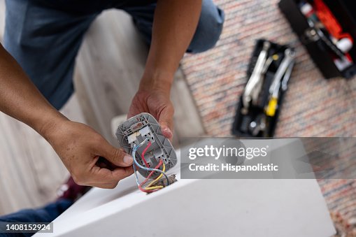 Close-up on a repairman fixing an electrical outlet Close-up on a repairman fixing an electrical outlet