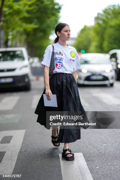 Chloe Ambre Maurin wear a white with embroidered multicolored yoke t-shirt, a black with gray FF monogram print pattern shoulder bag from Fendi, a...