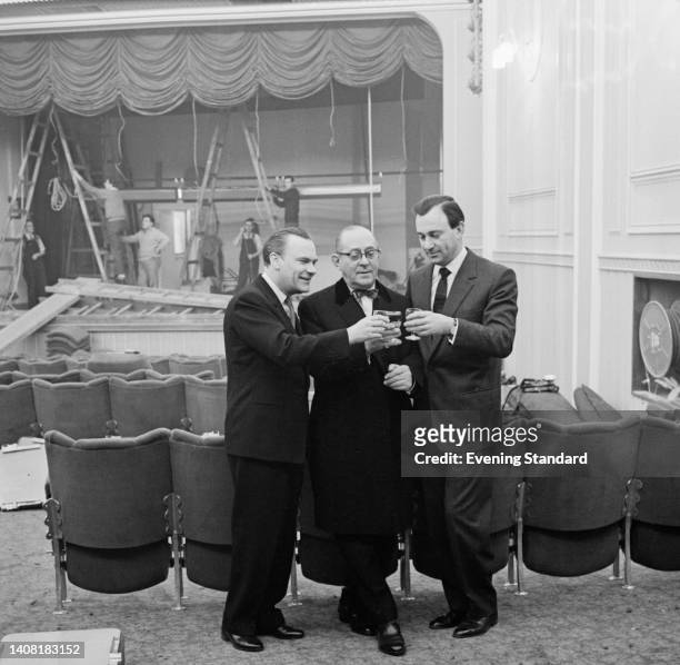 Theatre designer Carl Fisher, theatre owner Alfred Esdaile, and British theatre producer Harold Fielding ) raise a glass as the Prince Charles...