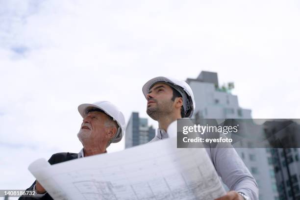 engineer is working on the roof of building. surrounding with high building. - a meeting place for the european digital industry stock pictures, royalty-free photos & images