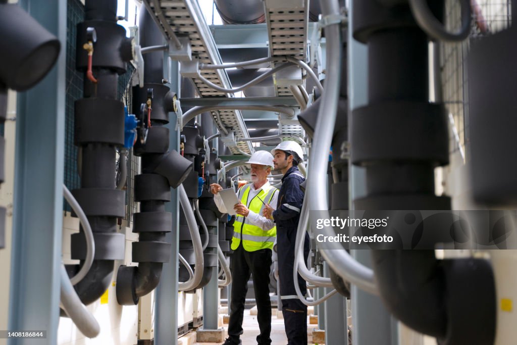 Engineer is working on the roof of building. Surrounding with high building.