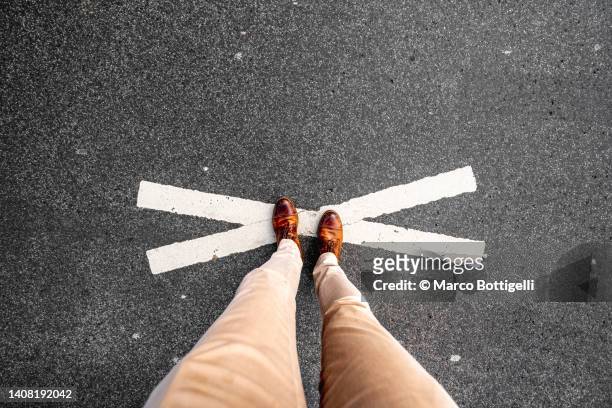 personal perspective of person standing on an cross shape road sign - wrong direction stock pictures, royalty-free photos & images