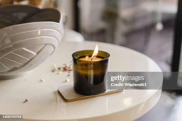 burning scented candle on table at home - bougie photos et images de collection
