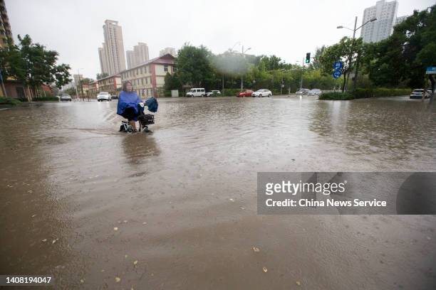 Cyclist rides along a flooded street amidst heavy rain on July 11, 2022 in Taiyuan, Shanxi Province of China.