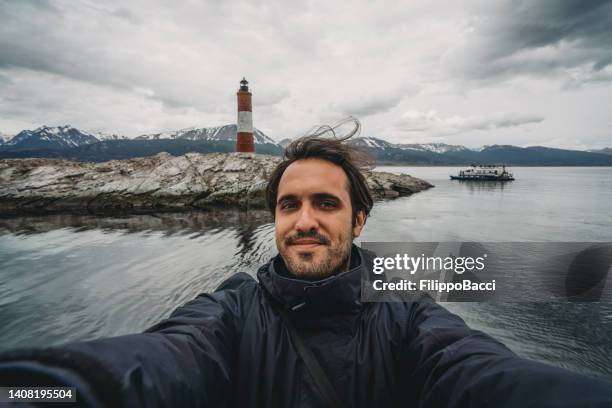 mann macht ein selfie in der nähe von the lighthouse pathfinders in der nähe von ushuaia - ushuaia stock-fotos und bilder