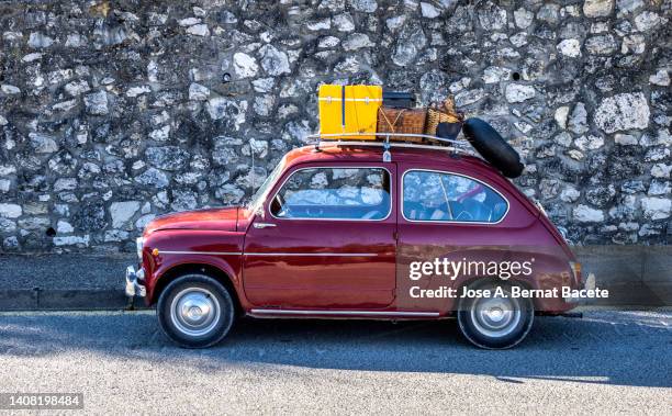 old car loaded with suitcases and fridge ready to go on vacation to the beach. - autos usados fotografías e imágenes de stock