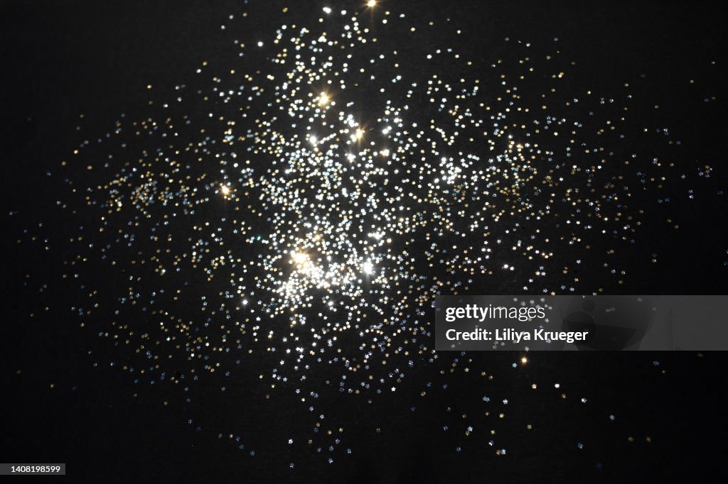 Gold stars and silver stars on a black background.