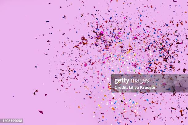 colorful glitter confetti on a pink background. - pink confetti stock pictures, royalty-free photos & images