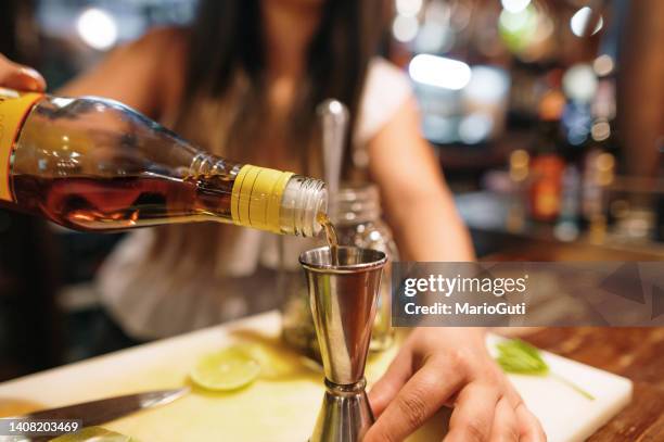 bartender pouring rum into a measuring glass - rum stock pictures, royalty-free photos & images