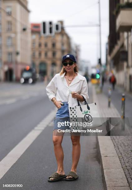 Sonia Lyson seen wearing a blue Highsnobity x New Era cap, a green striped sunglasses from Bottega Veneta, gold pendant necklace from Louis Vuitton,...
