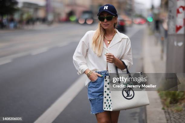 Sonia Lyson seen wearing a blue Highsnobity x New Era cap, a green striped sunglasses from Bottega Veneta, gold pendant necklace from Louis Vuitton,...