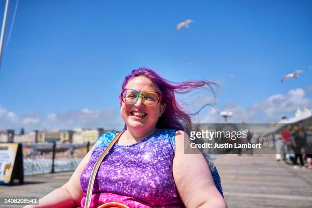 woman in wheelchair with colourful clothing posing for a photo - disabilitycollection fotografías e imágenes de stock