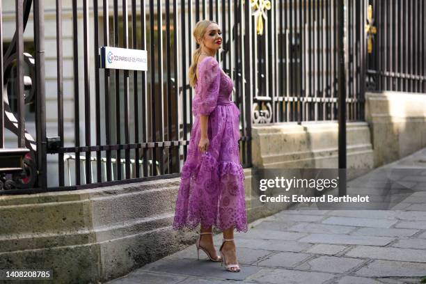 Guest wears diamond earrings, a diamonds necklace, a purple cut-out pattern / square-neck / puffy short sleeves / ruffled long dress, a diamonds...