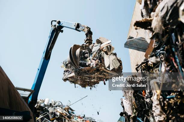 hydraulic mechanical grabber in a scrap metal yard - gestione-dei-rifiuti foto e immagini stock