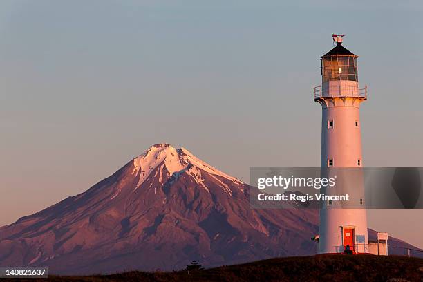 cape egmont lighthouse with mount taranaki - cape egmont lighthouse stock pictures, royalty-free photos & images