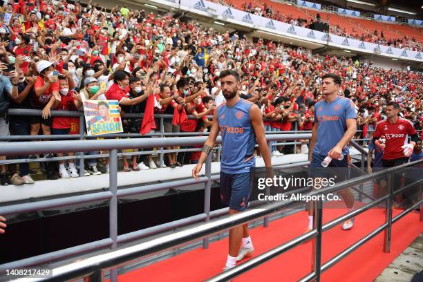 Bruno Fernandes and Harry Maguire of Manchester United enters the stadium as fans cheer during their open training session at the Rajamangala Stadium...
