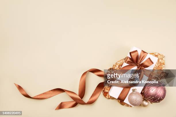 xmas still life composition with pastel pink christmas ornaments on solid beige background - matter presents ストックフォトと画像
