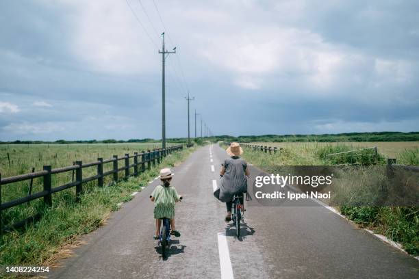 mother and child riding bicycle through farmland, japan - okinawa prefecture stock pictures, royalty-free photos & images