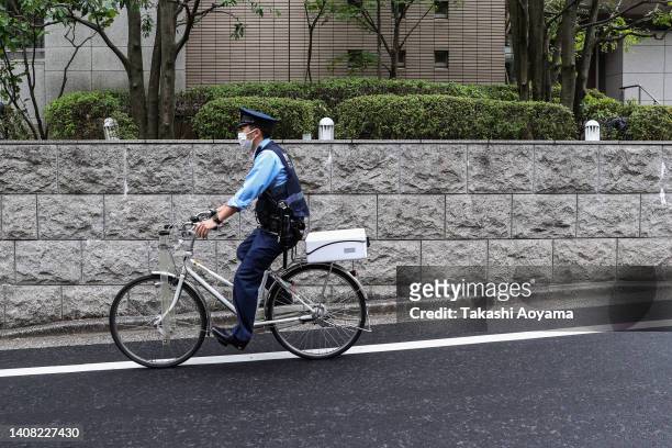 Police officer on a bicycle cycles in front former Japanese Prime Minister Shinzo Abe's residence on July 12, 2022 in Tokyo, Japan. Abe was...