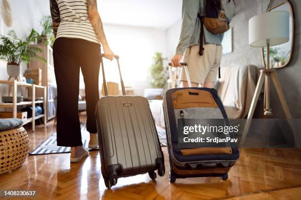 unrecognizable couple arriving at the accommodation with their suitcases - arriving home stockfoto's en -beelden