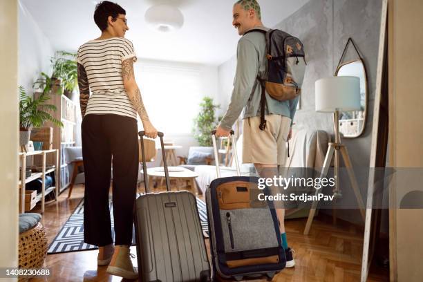 young caucasian couple arriving at the accommodation with their suitcases - apartment tour stock pictures, royalty-free photos & images