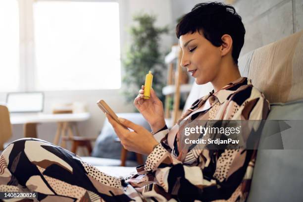 modern young woman using mobile phone while smoking vape - quitting smoking stock pictures, royalty-free photos & images